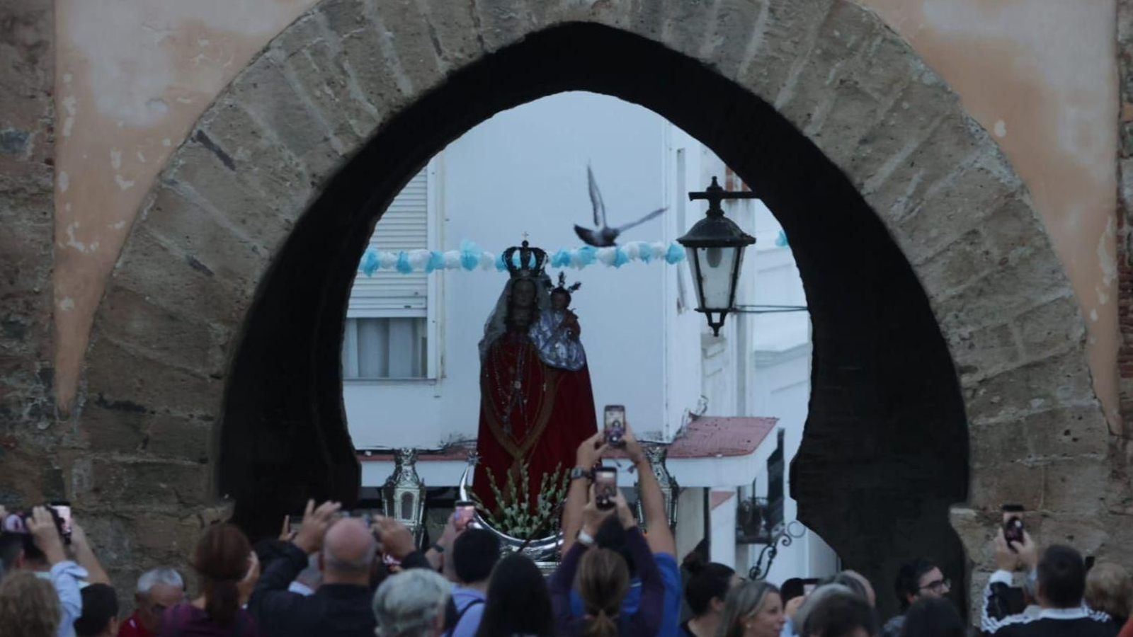 La Virgen de la Luz cruza el arco de la Puerta de Jerez para volver a su santuario tras tres semanas en Tarifa.