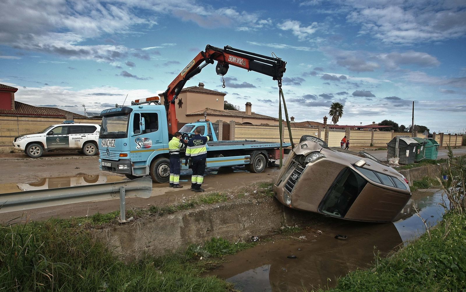 La grúa intenta recuperar el todoterreno que embistió al coche patrulla de la Guardia Civil, ayer.