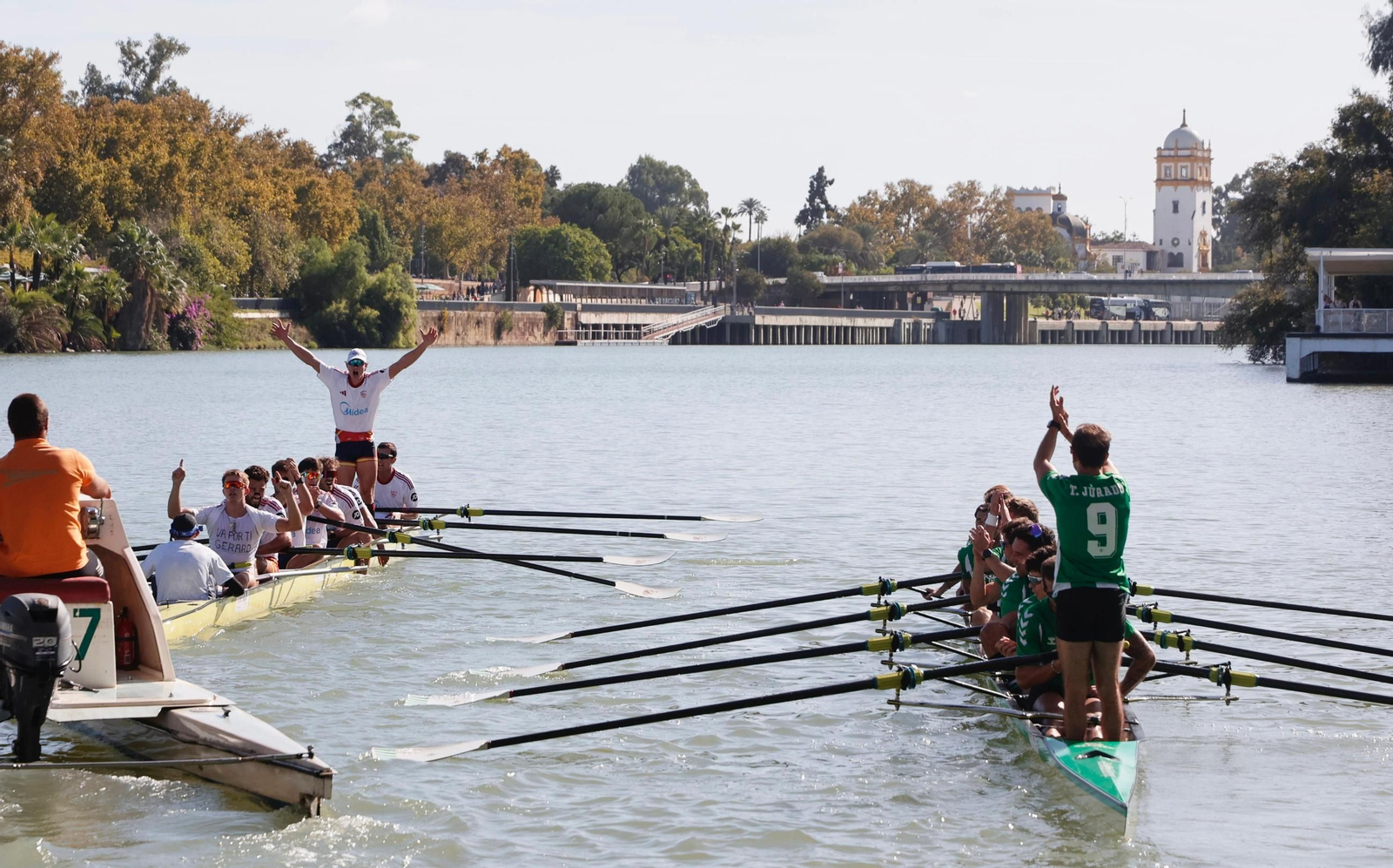 El bote sevillista celebra el triunfo mientras Tomás Jurado aplaude con sus compañeros desde el bético.