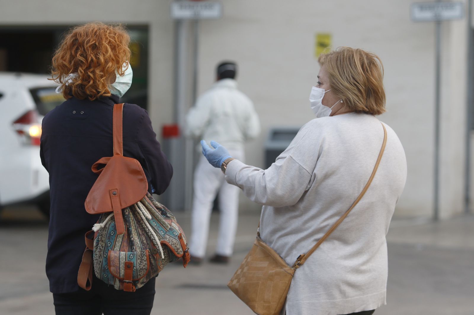 Mujeres con mascarillas a las puertas de un hospital.