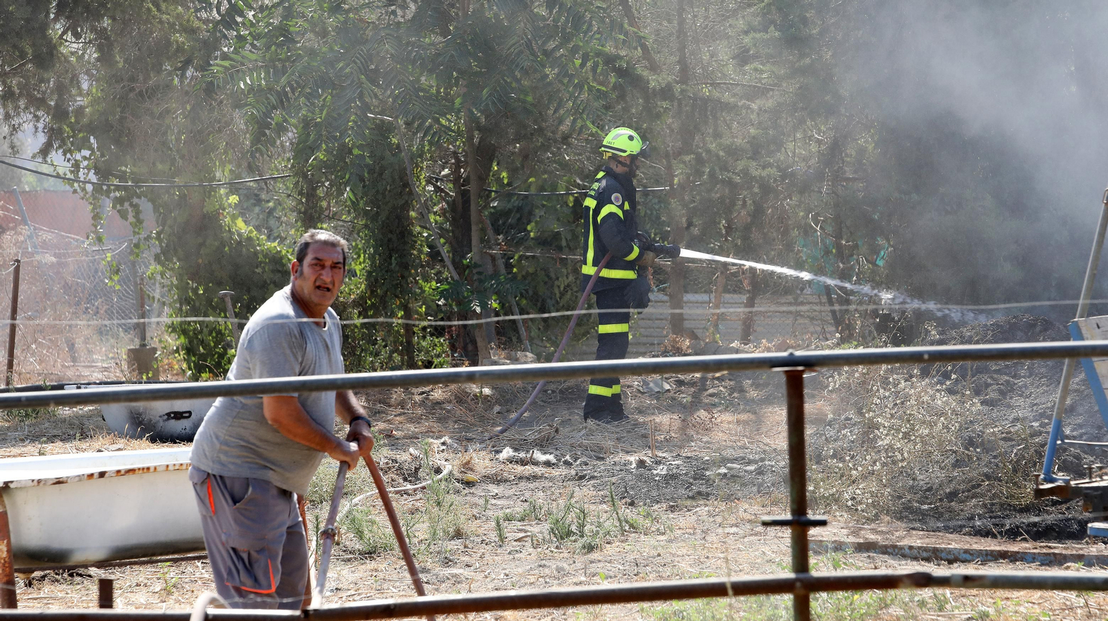 Bomberos refrescando en una finca de la Hijuela del Serrallo.