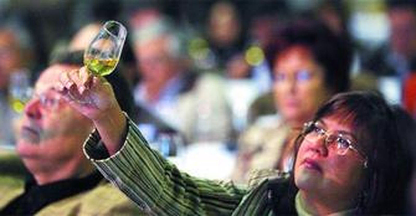 Una participante en la cata observa la copa de vino en las instalación de la Unión de Viticultores