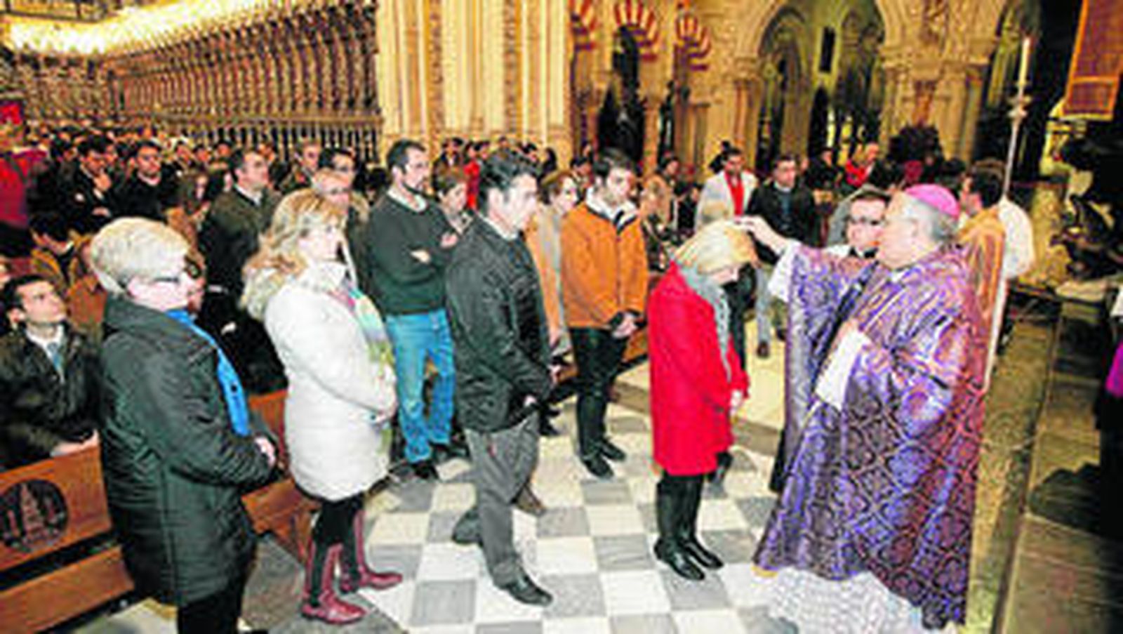 El obispo, Demetrio Fernández, impone la ceniza a un feligresa.