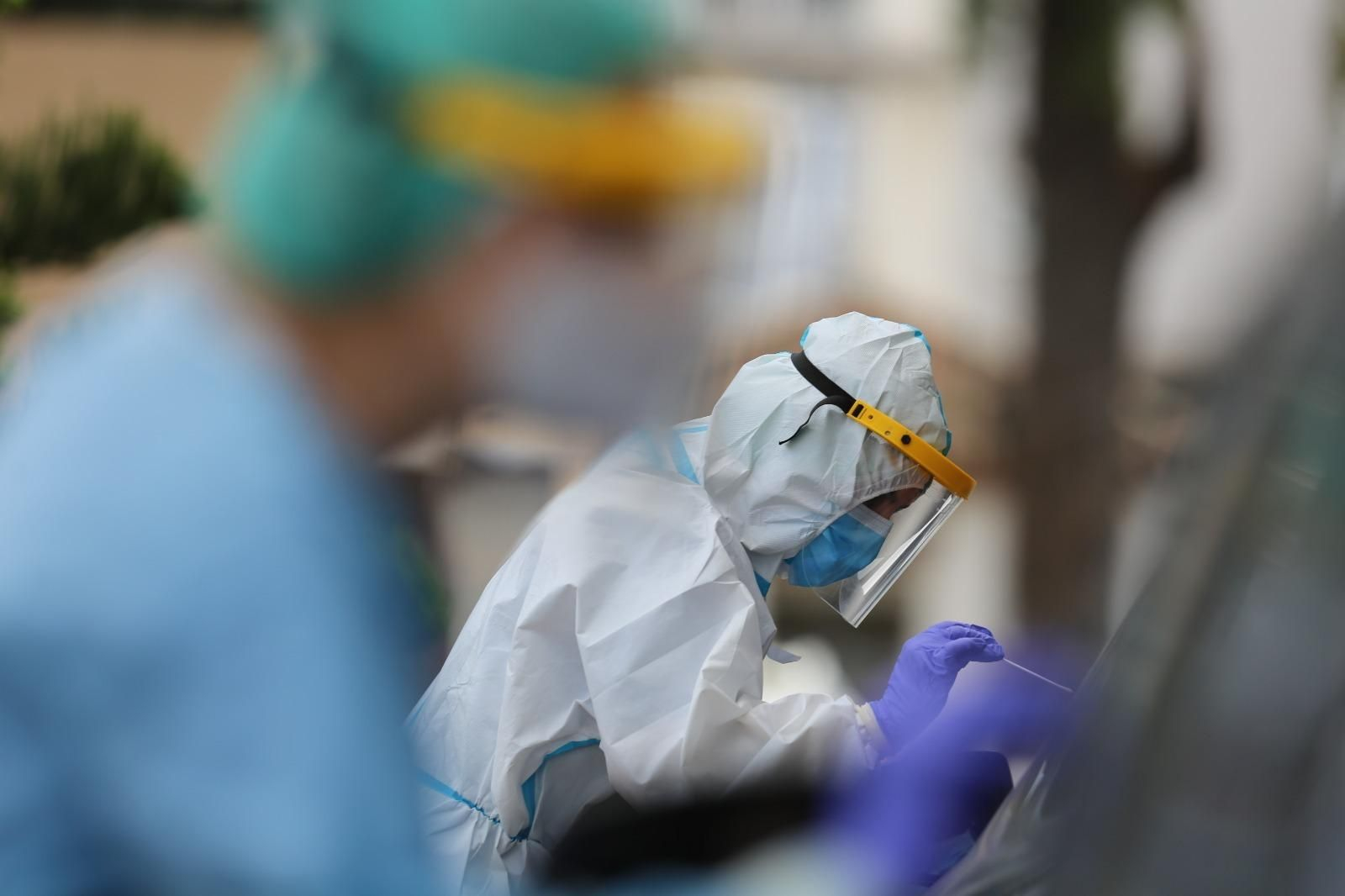 Un sanitario toma muestras a una persona para su análisis.