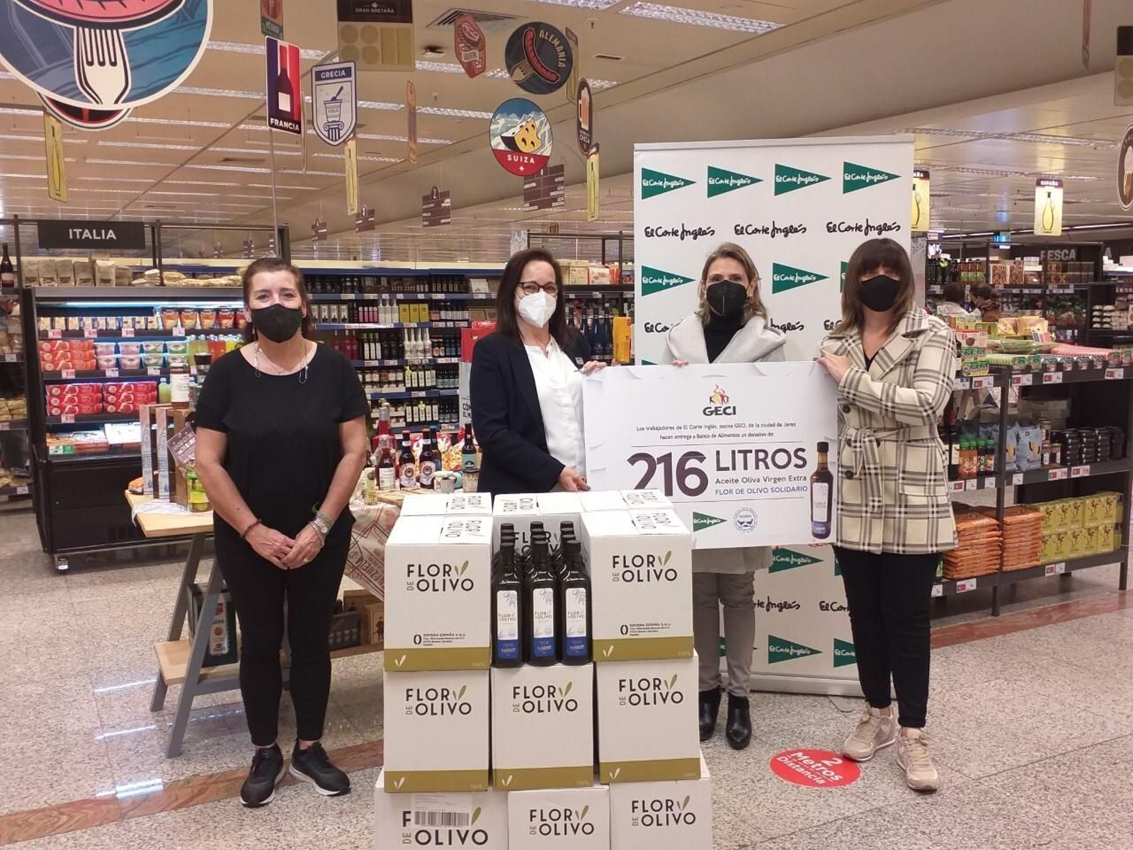 Voluntarias posan con los litros de aceite recopilados para la donación.