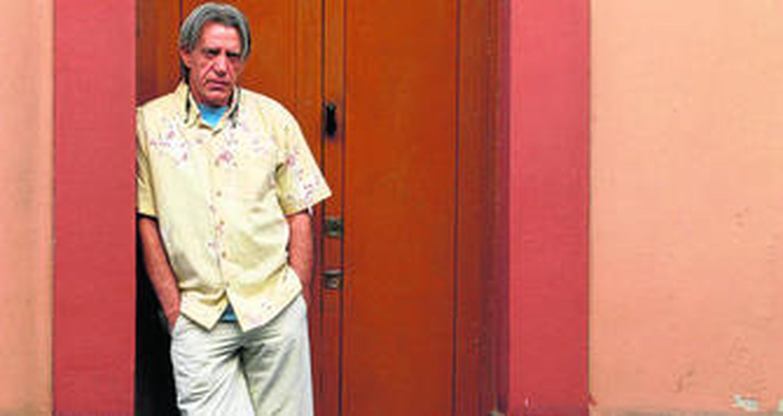 El cantautor Luis Pastor posa junto a la puerta de una vivienda de Córdoba.