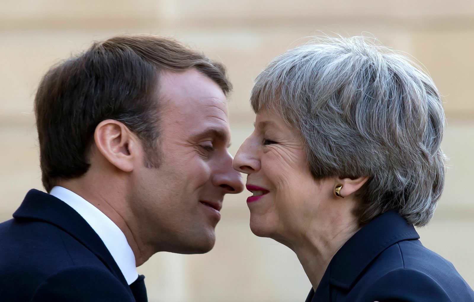 Macron y May se besan a las puertas del Elíseo en París.