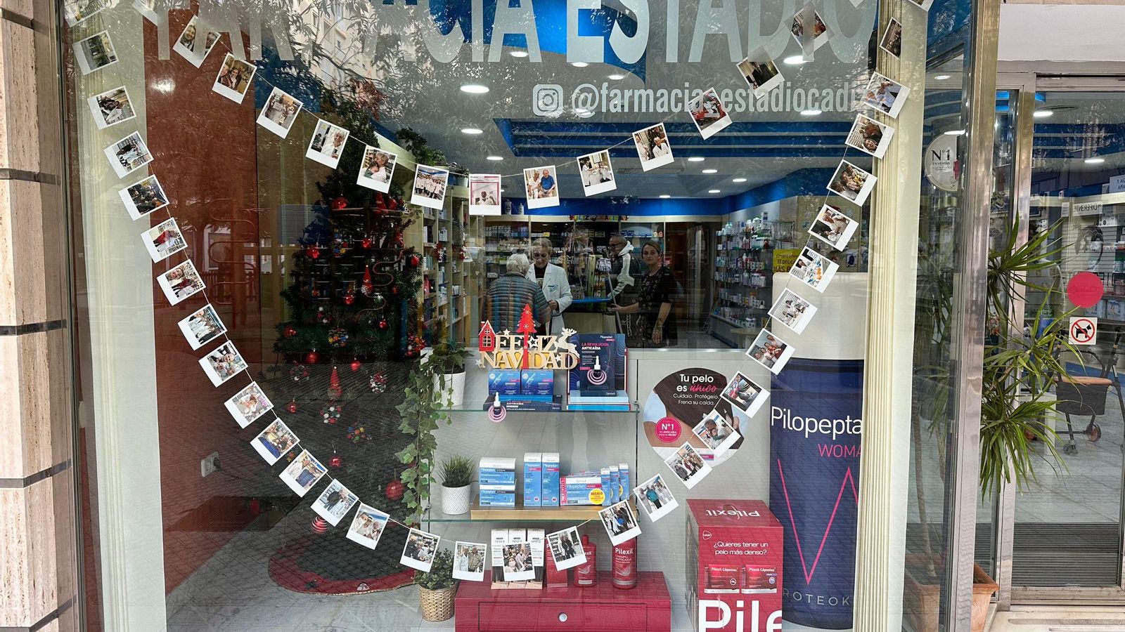 Guirnalda con fotos de Pedro en el escaparate.