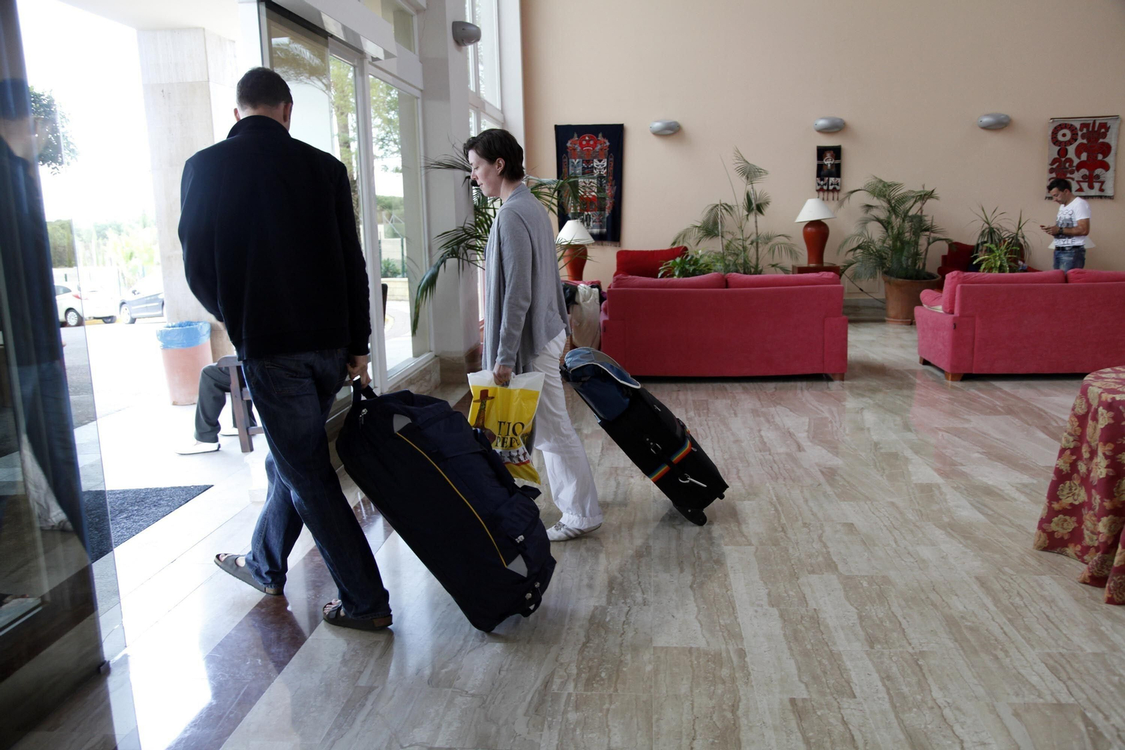Dos turistas salen de un hotel