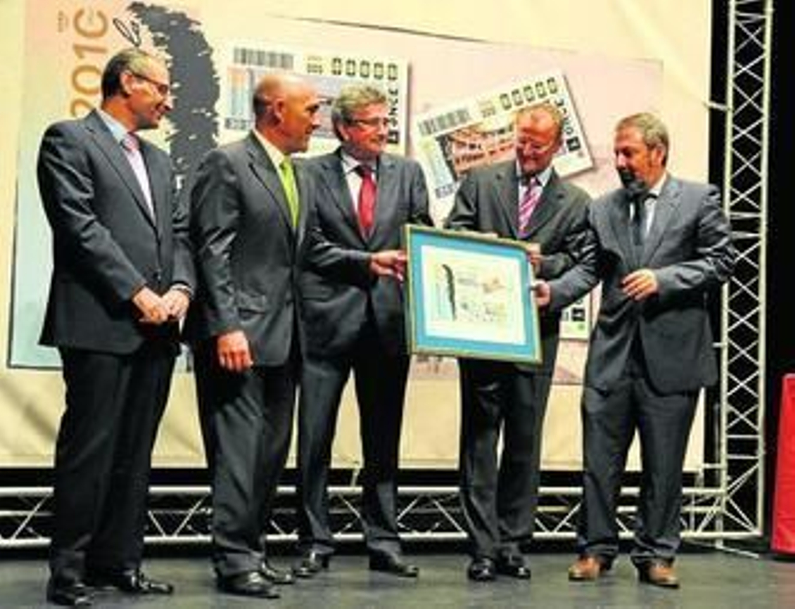 Responsables de la ONCE y políticos sostienen una copia de los cuatro cupones con imágenes de La Isla.