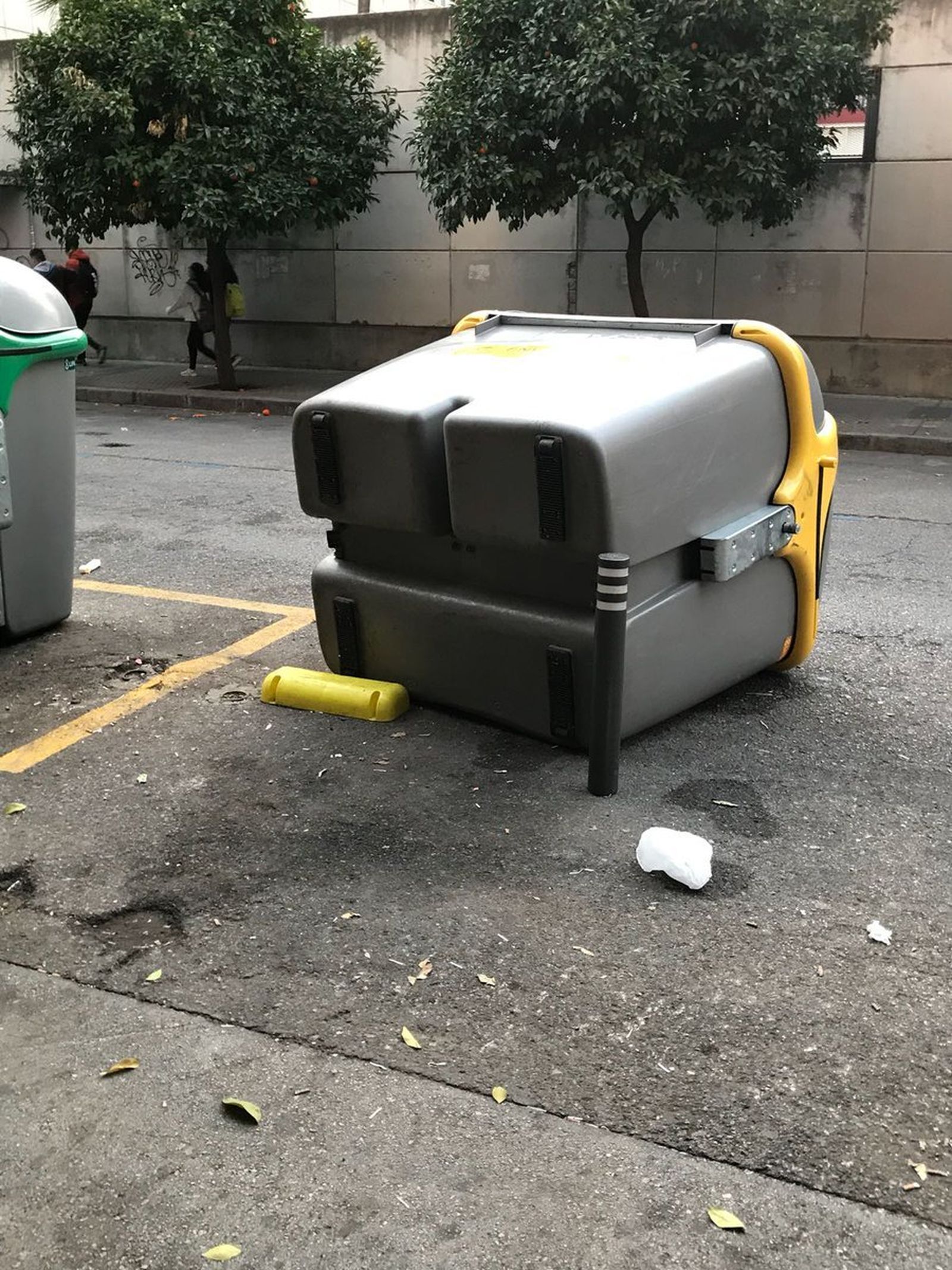 Un contenedor tirado al suelo en la zona de Viapol afectada por la 'botellona'