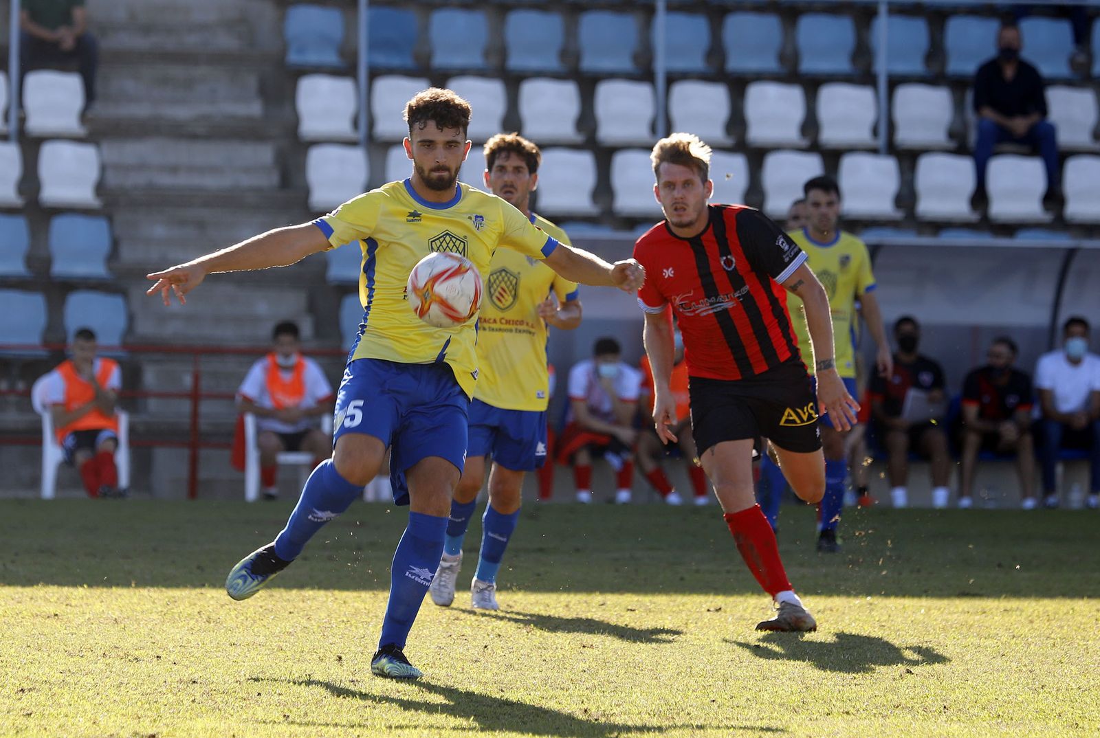 Paúl despeja el balón en presencia de un adversario.