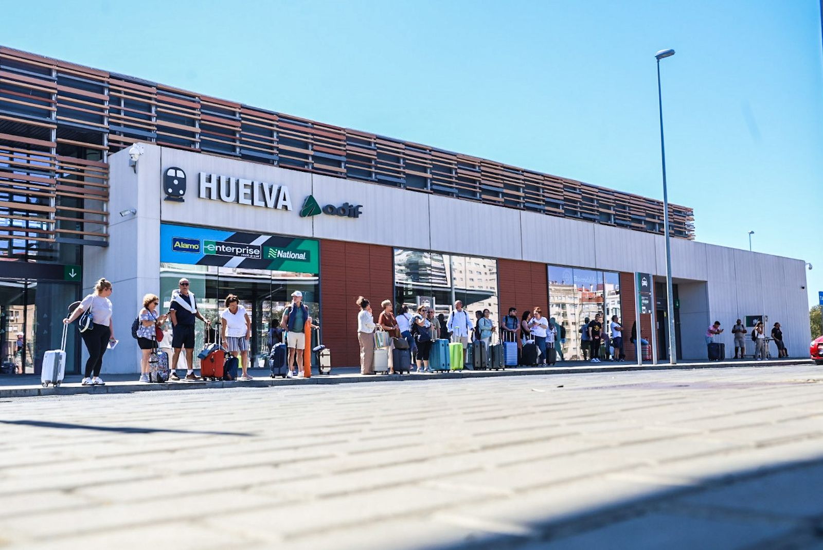 Pasajeros esperando autobuses en la estación de Renfe de Huelva.