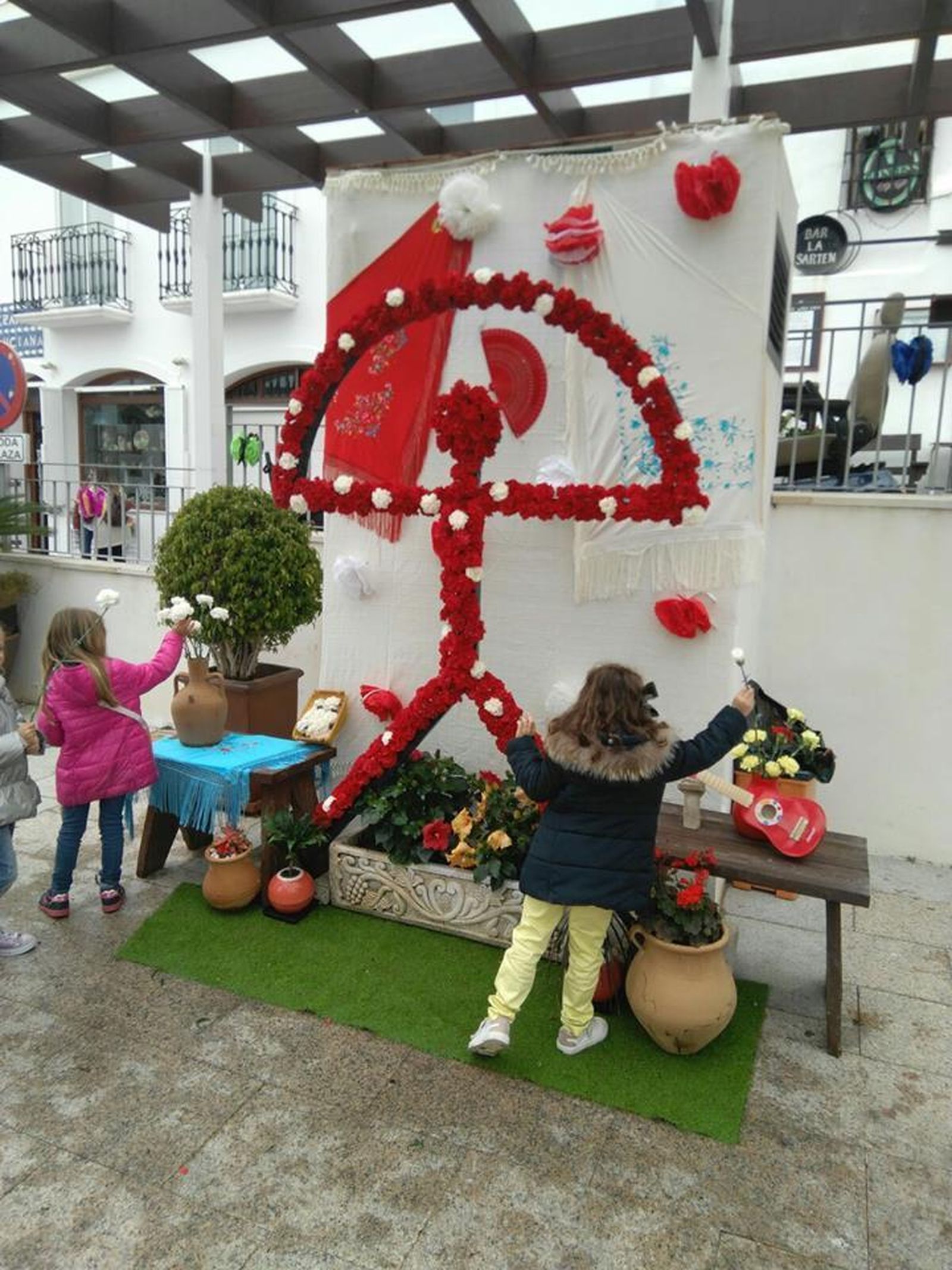 Niños mojaqueros adornando uno de los nueve indalos instalados por el municipio.