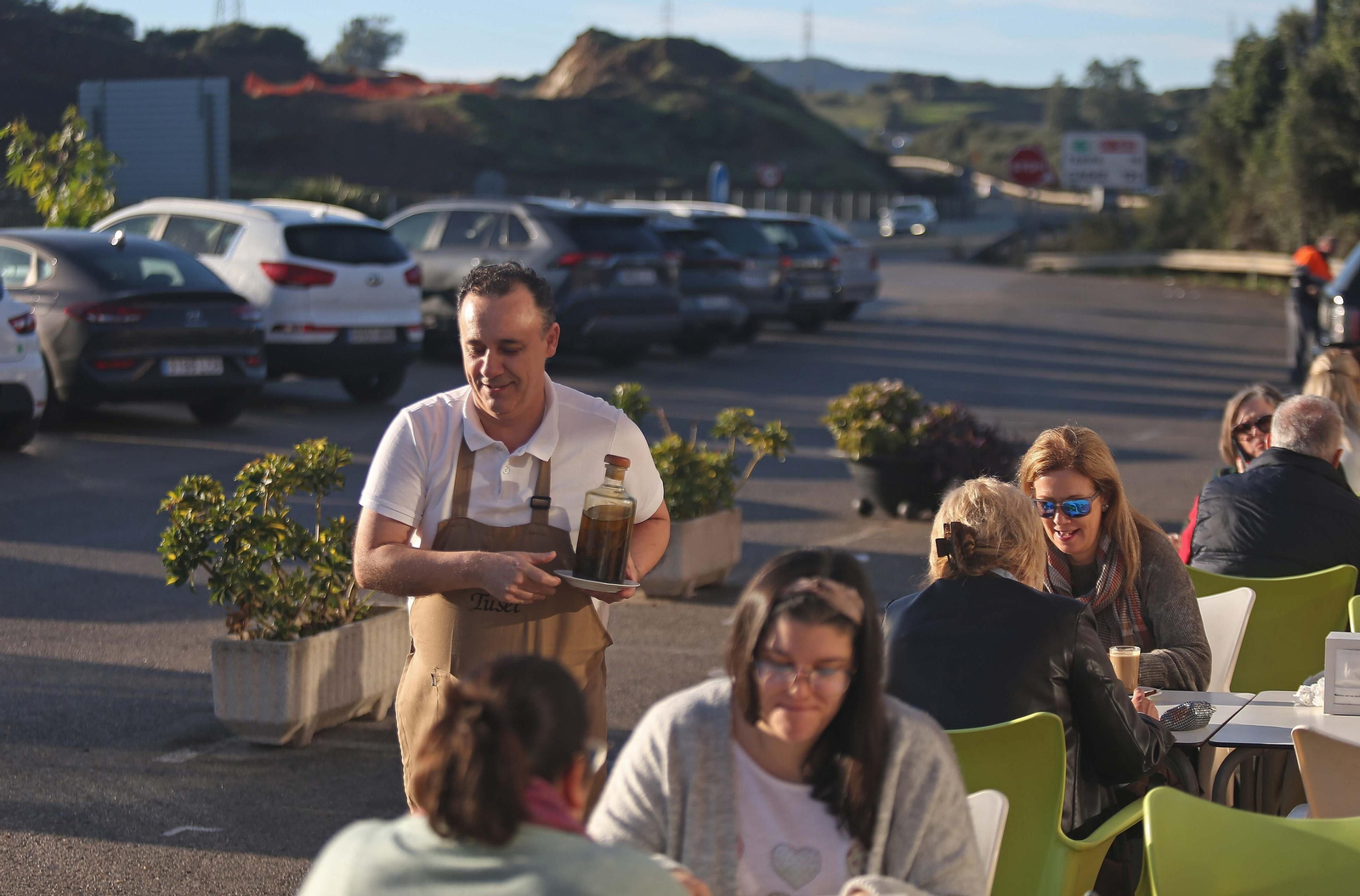 Un camarero atiende una terraza con clientes, este martes.