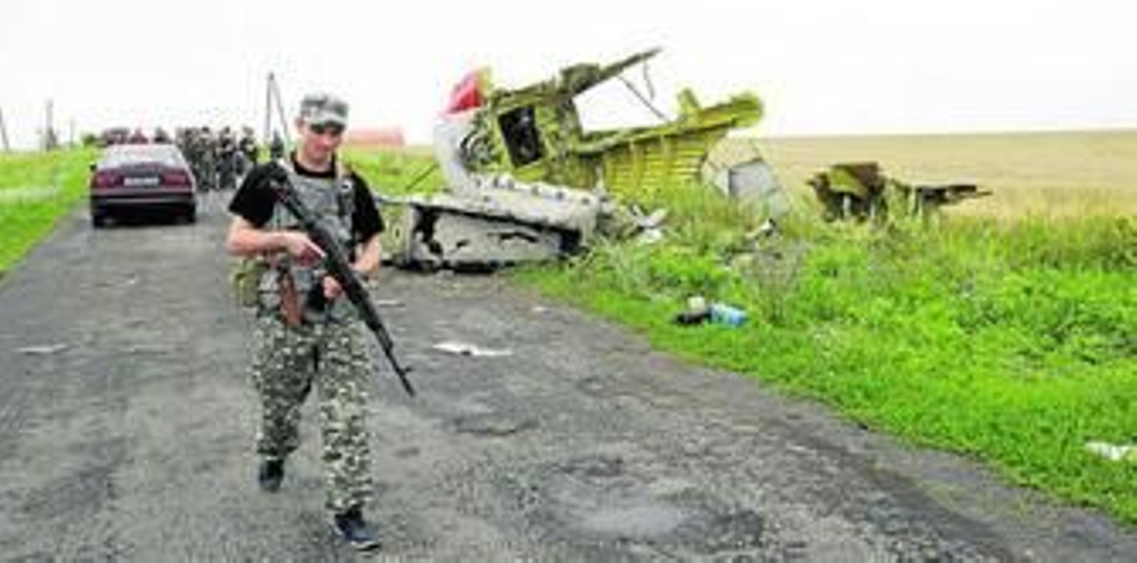 Un rebelde prorruso pasa al lado de restos del fuselaje del avión Boeing 777 que se estrelló el jueves en Donetsk.