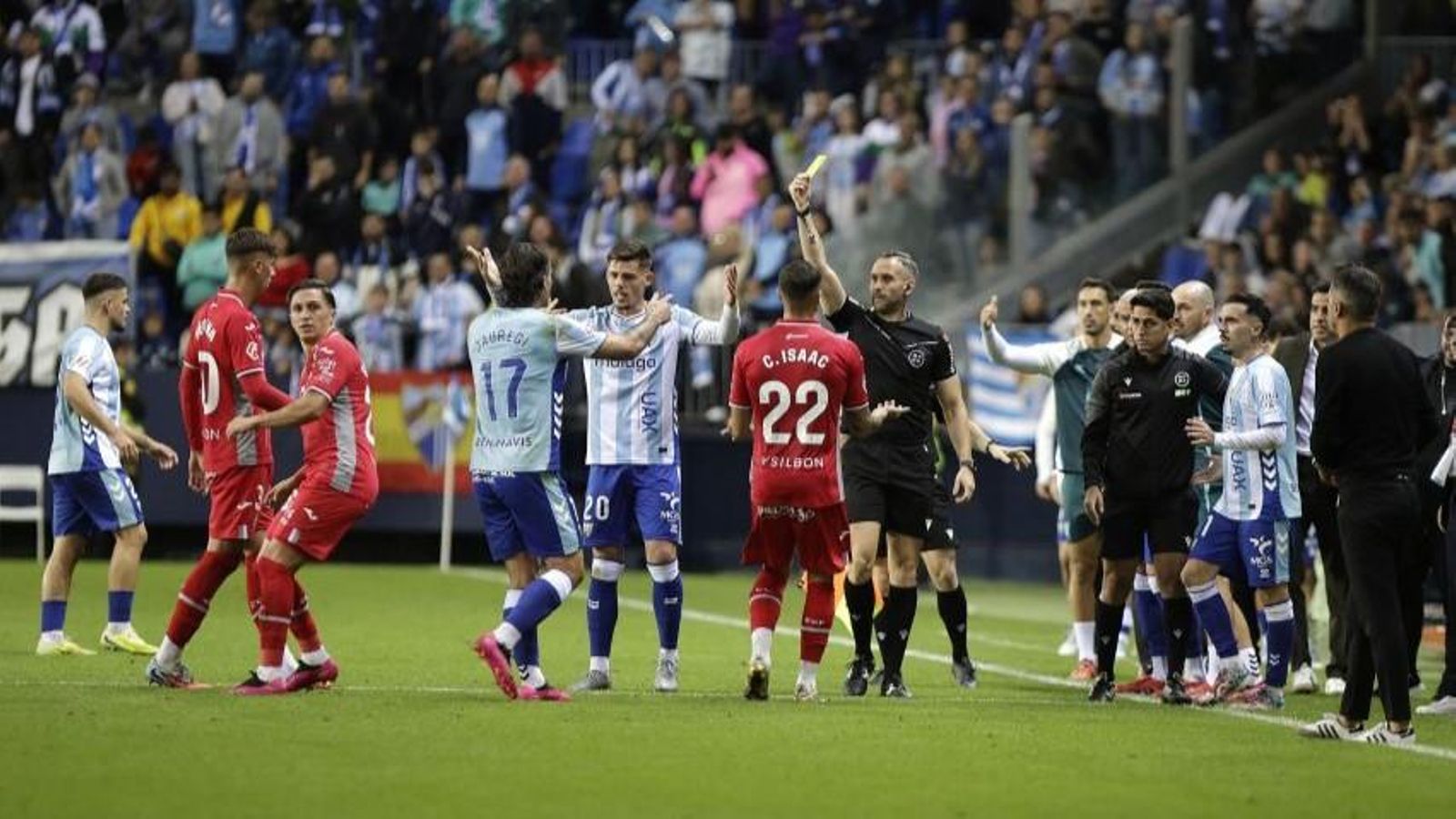 Orellana Cid muestra la tarjeta amarilla a Carracedo en el Málaga - Córdoba CF.