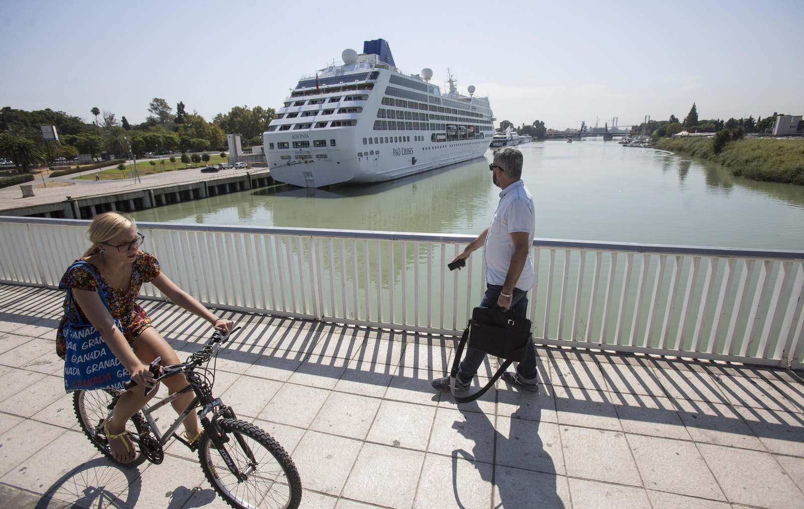 Un triciclo para turistas y un crucerista salen del muelle de las Delicias.