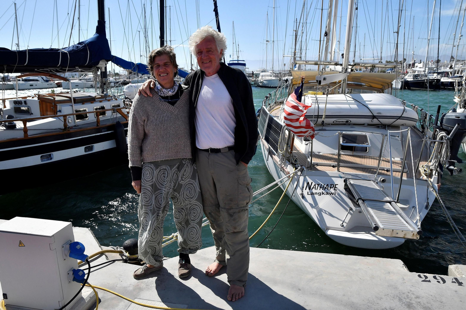 Los suizos Natalie y Hans Peter, junto al  velero en el que pasan la cuarentena en Almerimar.