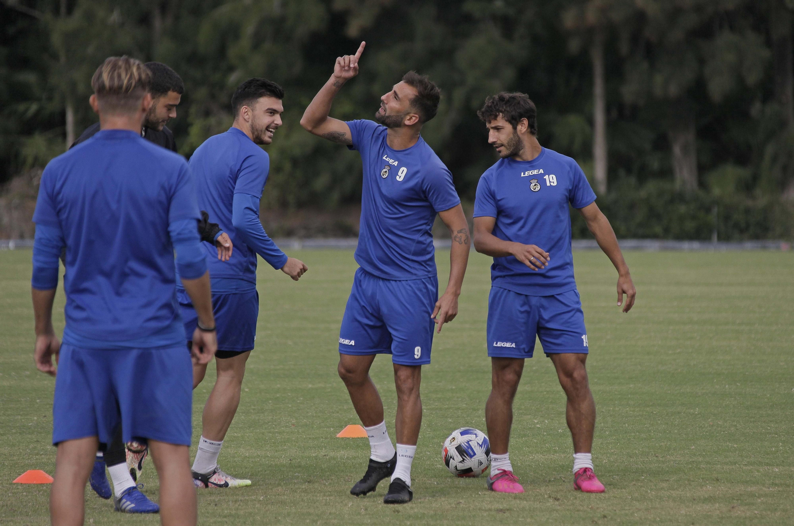 Pito Camacho señala al cielo ante la mirada de Javi Forján y Chironi durante un entrenamiento