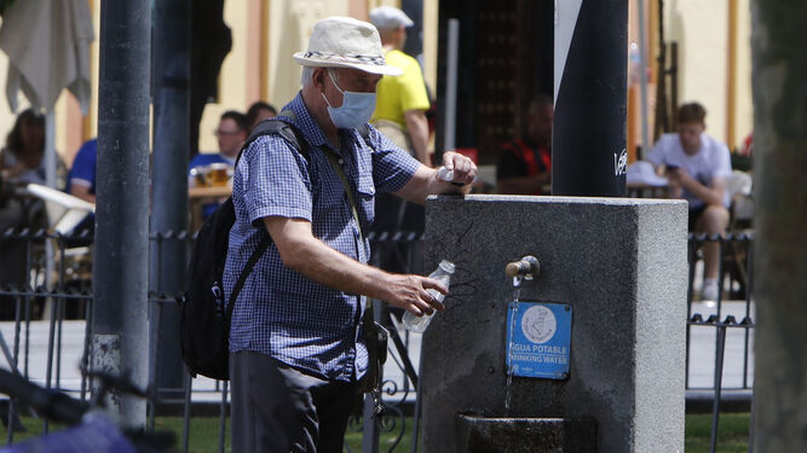 Un hombre se acerca a una fuente de agua.