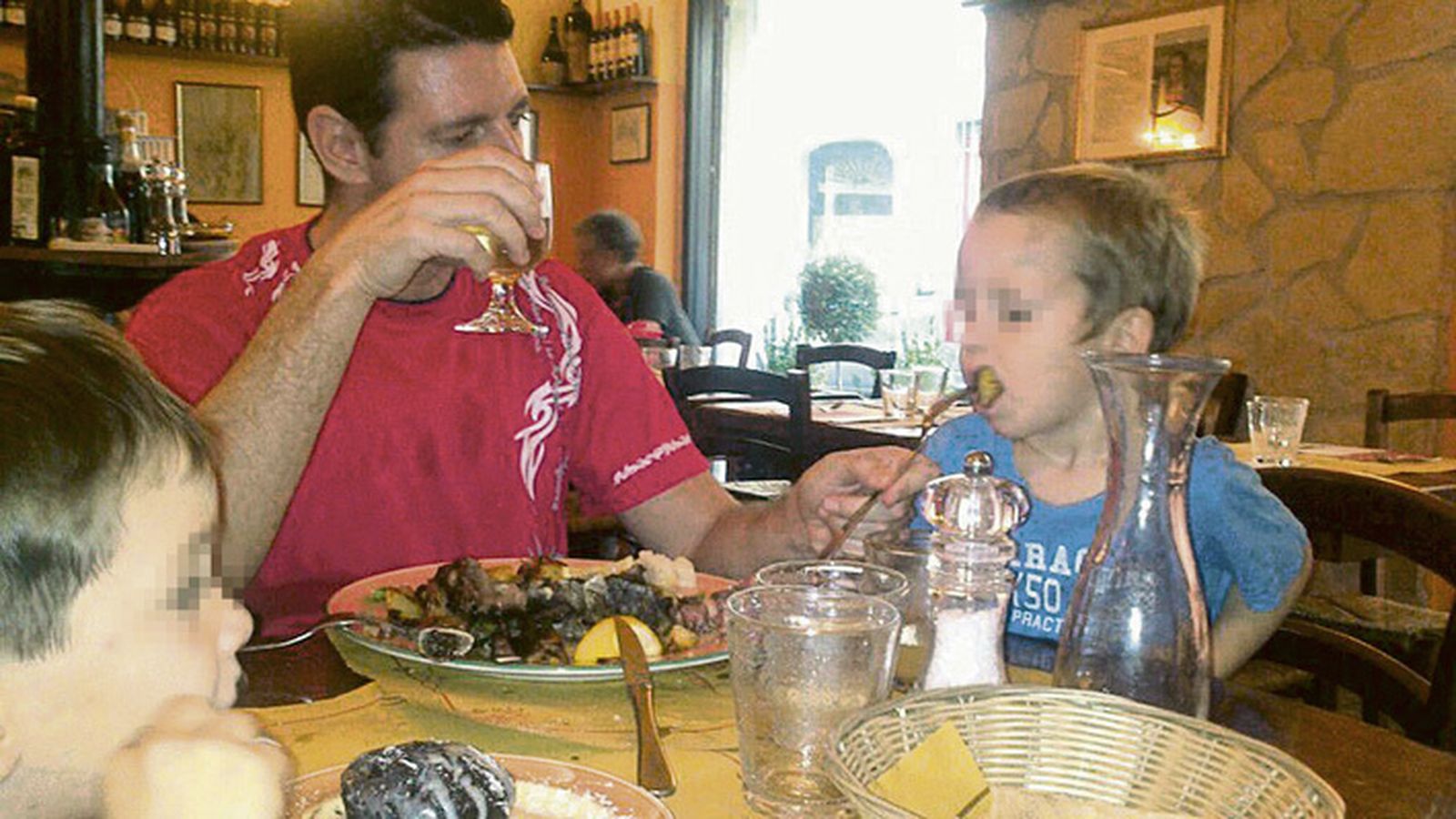 Sergio Oliva da de comer a uno de sus hijos.