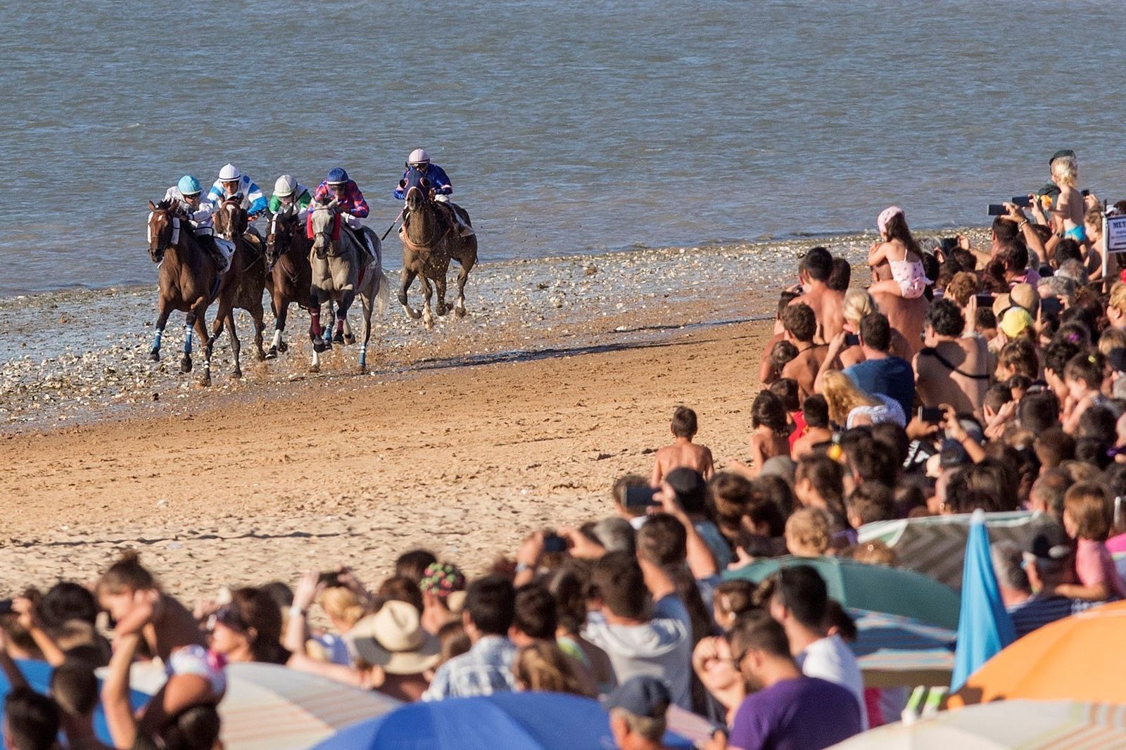 El público presencia una de las carreras en la orilla de la playa de Sanlúcar.