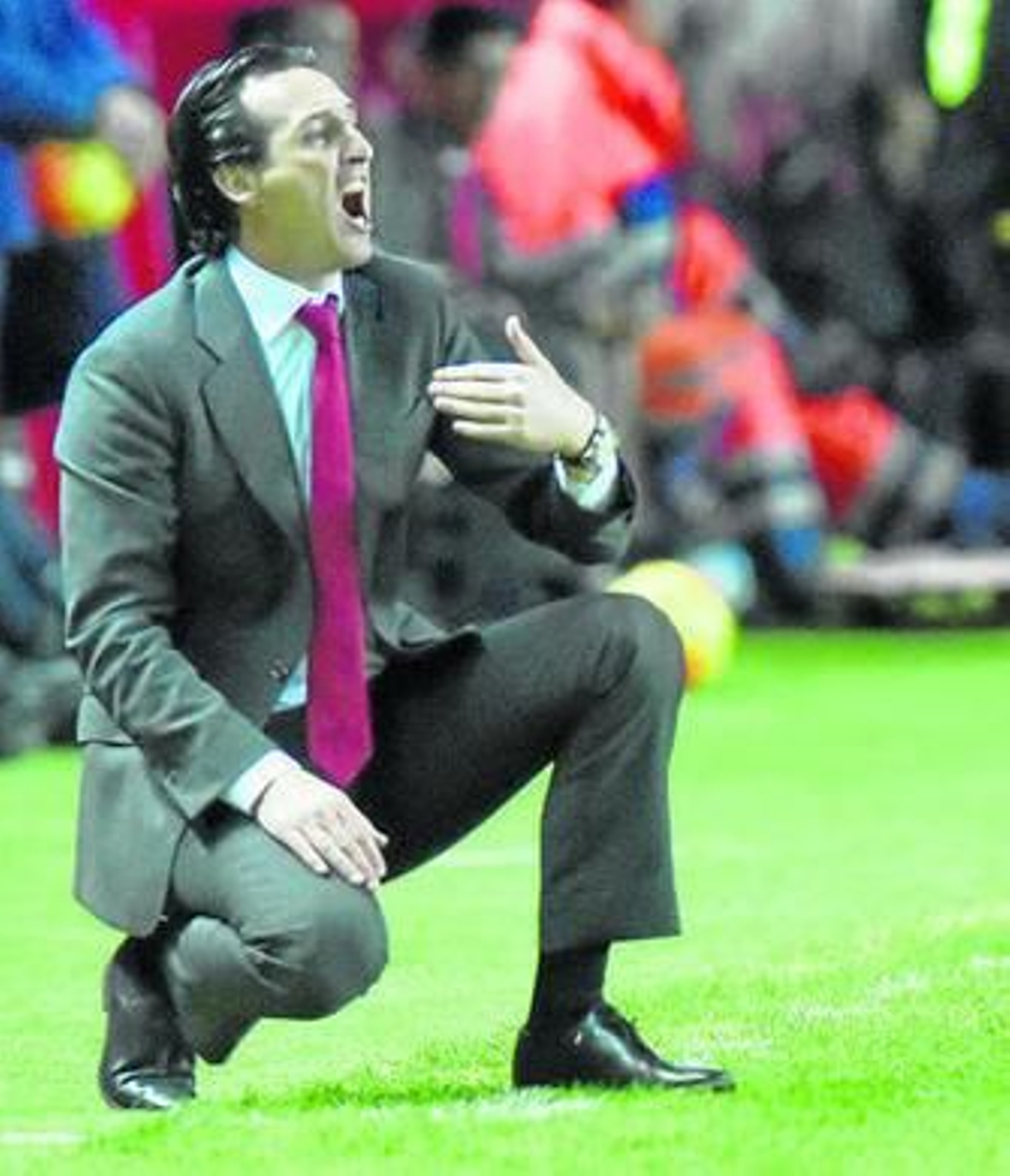 Emery, en su clásica postura en cuclillas, da órdenes.