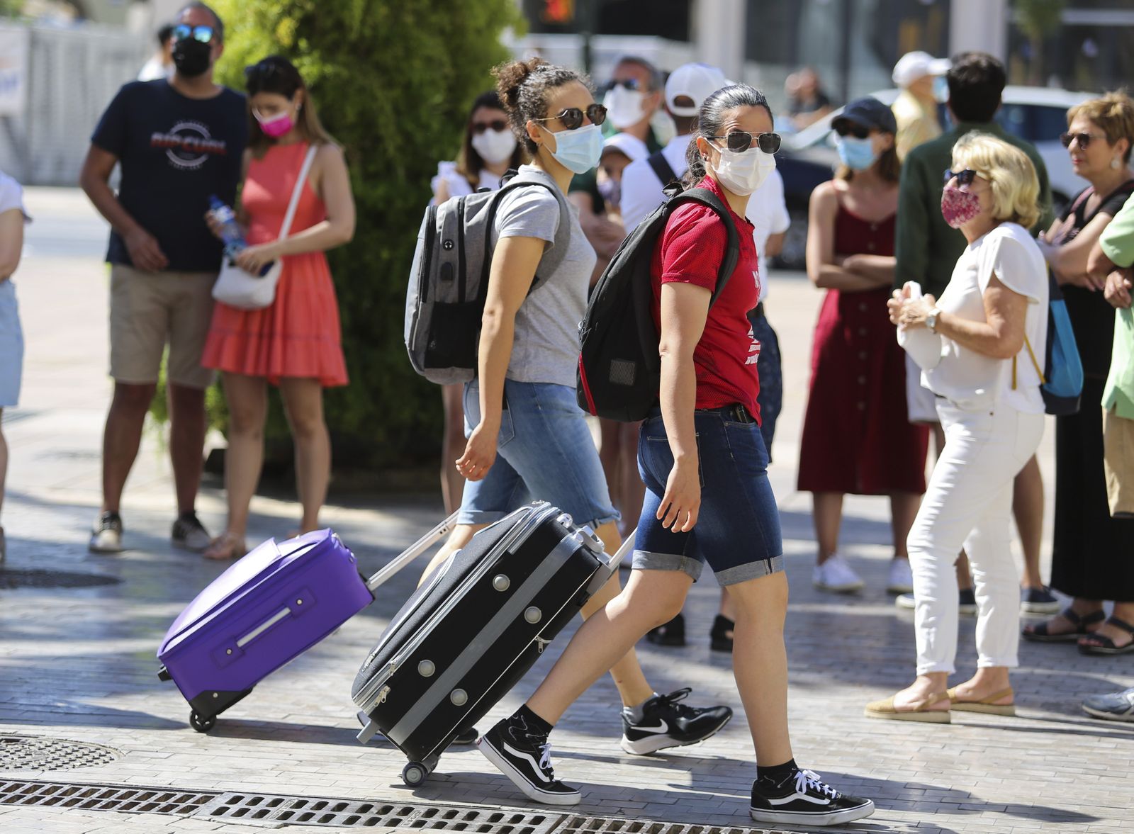 Dos turistas con maletas por el centro de Málaga.
