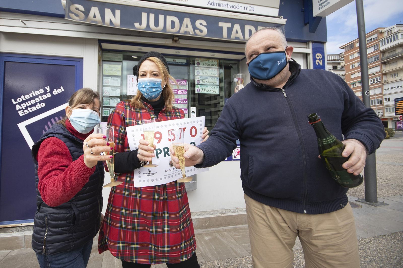 Los dueños de la administración 29 de Granada muestran orgullosos su cartel con el primer premio del Sorteo Del Niño de 2021