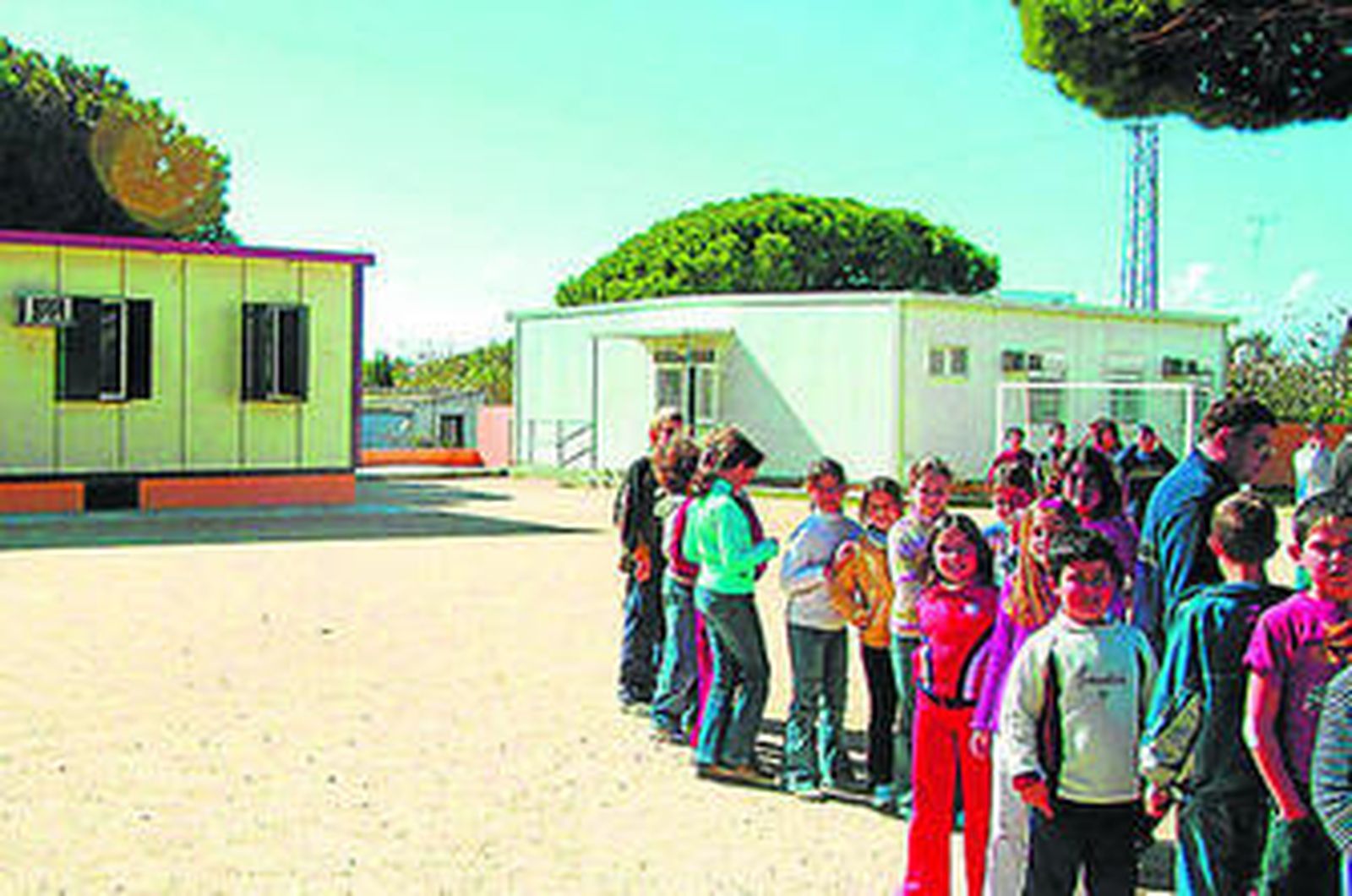Los alumnos esperan en la fila para entrar a sus clases en aulas prefabricadas.