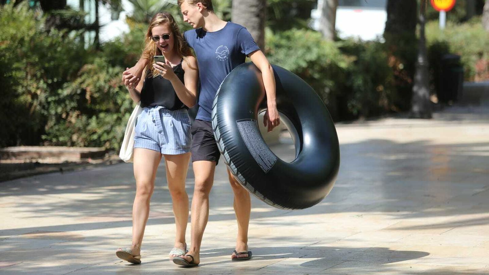 Una pareja pasea por la capital con un flotador.