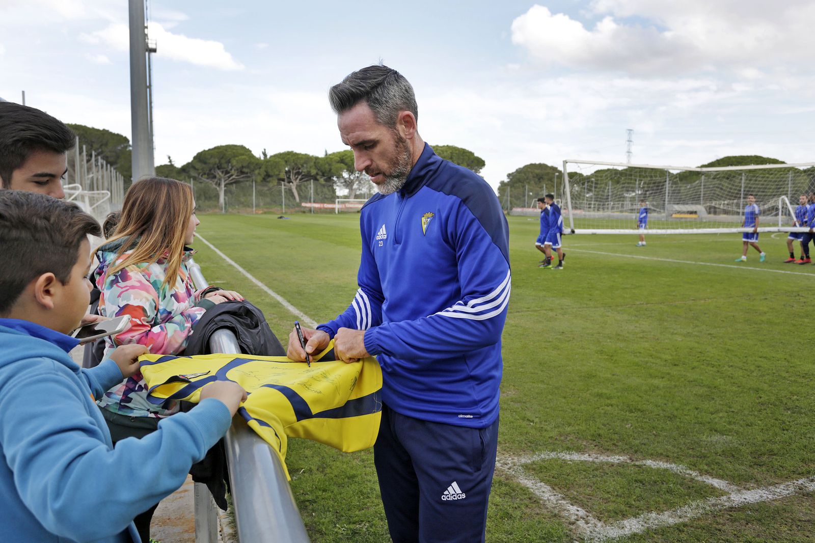 Abel Gómez firma un autógrafo en una camiseta del Cádiz al finalizar un entrenamiento en El Rosal.