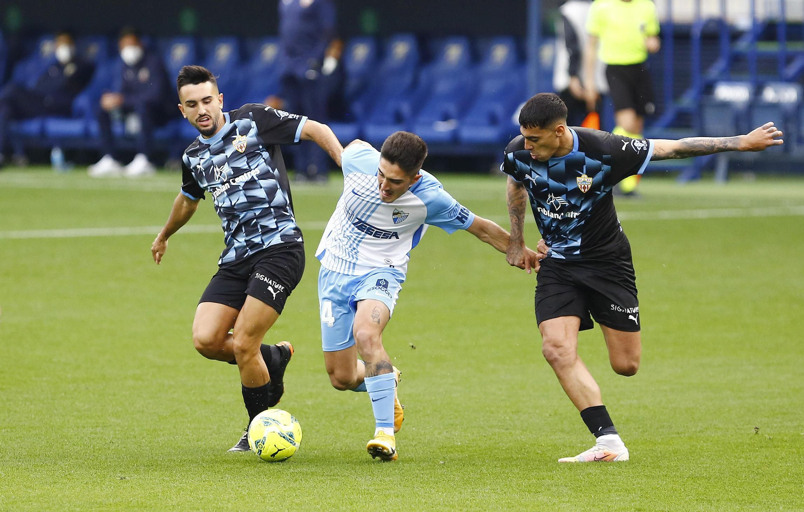 Julio Martínez, entre dos jugadores del Almería la pasada temporada.