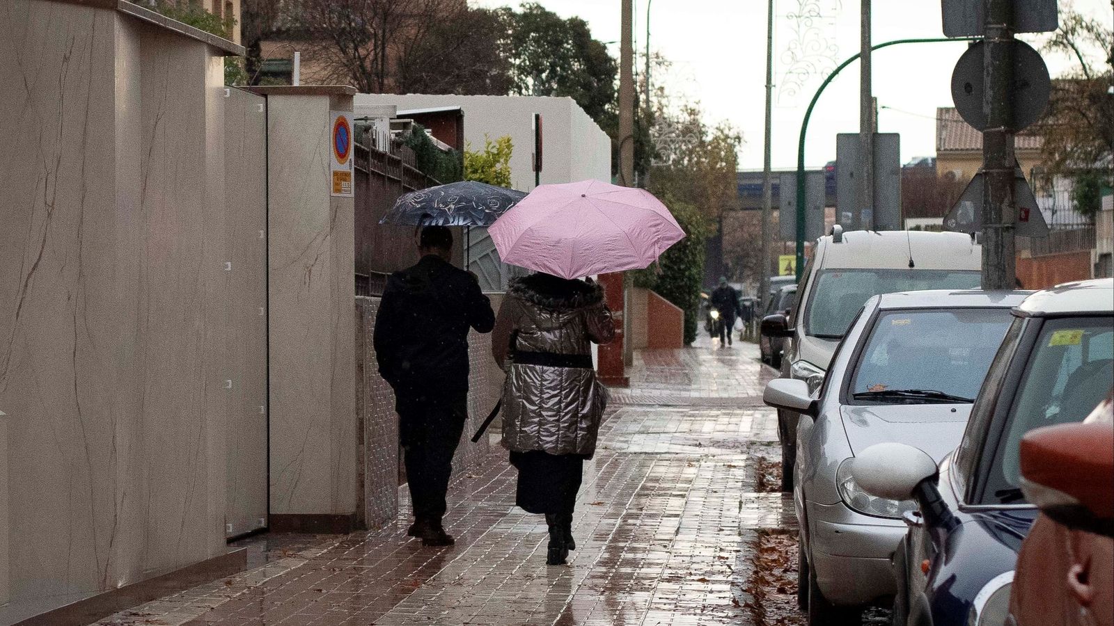 Dos personas caminan bajo la lluvia este domingo