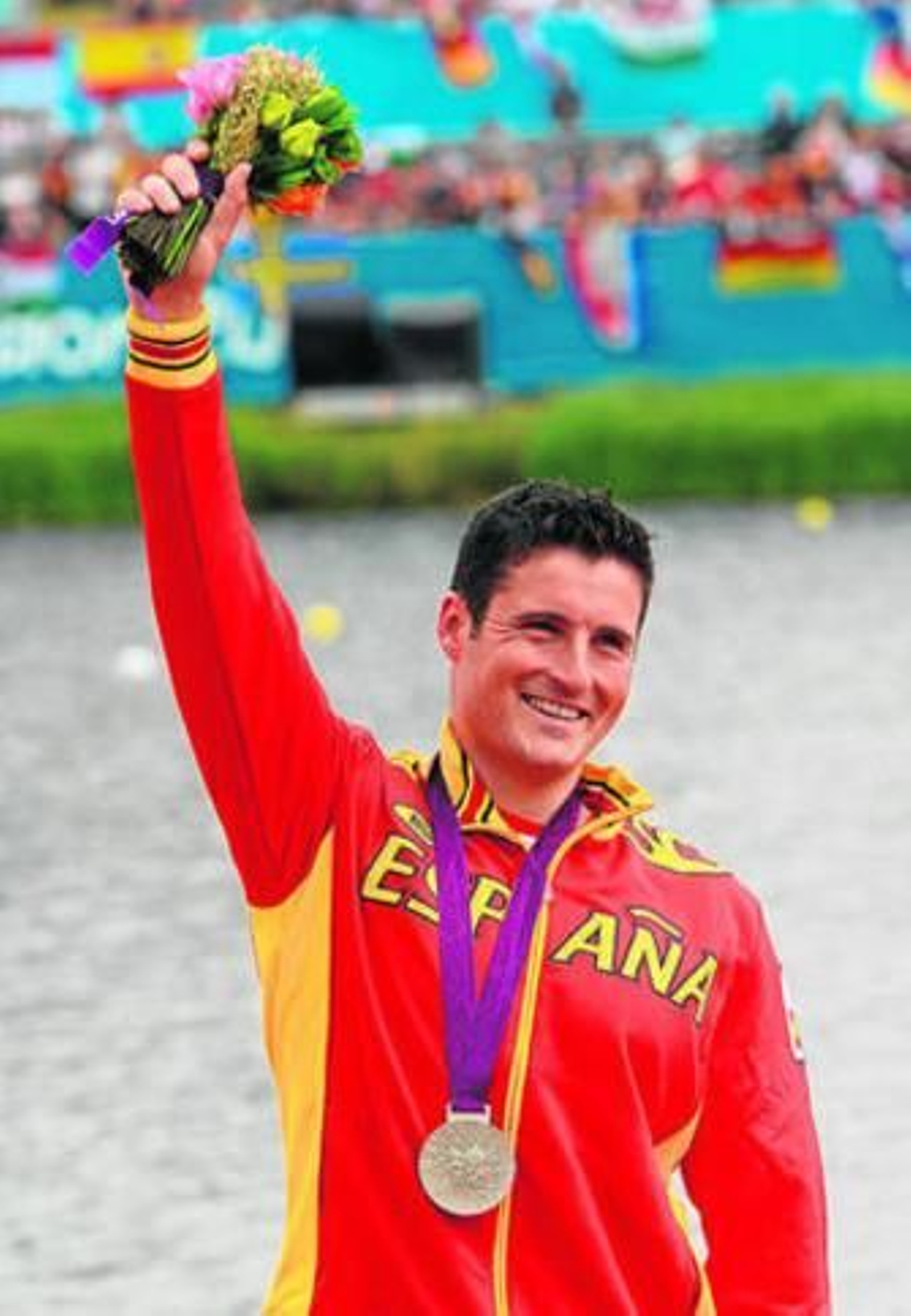 David Cal saluda sonriente con su medalla de plata.
