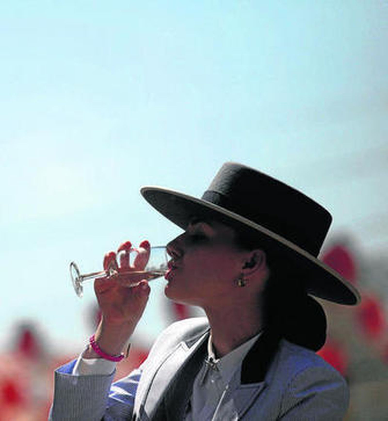 Una joven amazona bebe una copa de vino en el real.