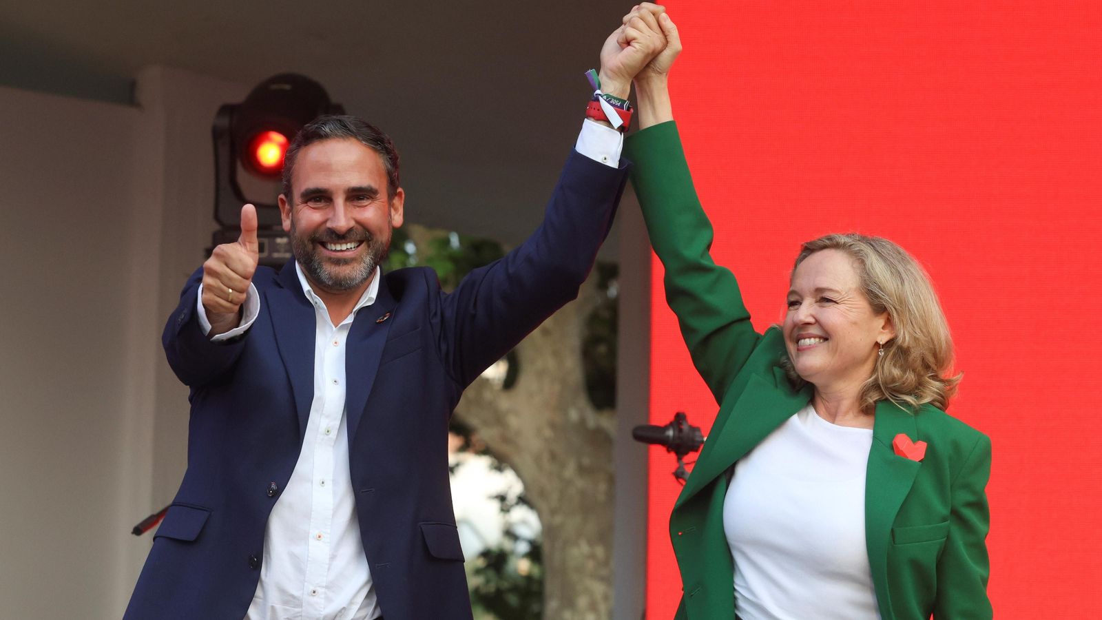 Dani Pérez levanta el pulgar, mientras Nadia Calviño, vicepresidenta del Gobierno, levanta su brazo.