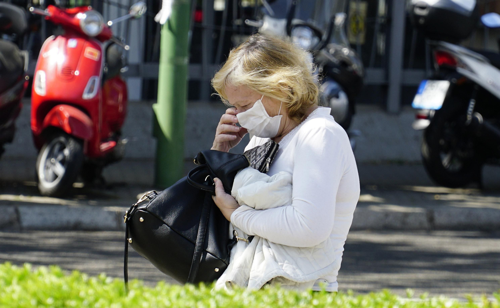 Una mujer habla por teléfono con la mascarilla puesta.