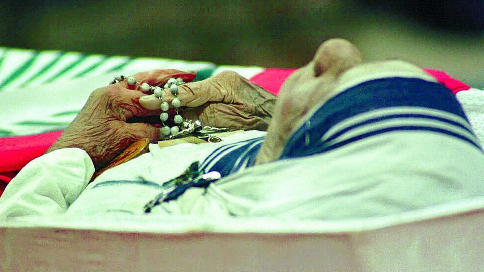 La madre Teresa reposa en su féretro, con un rosario y un crucifijo entre las manos, durante su funeral en 1997.