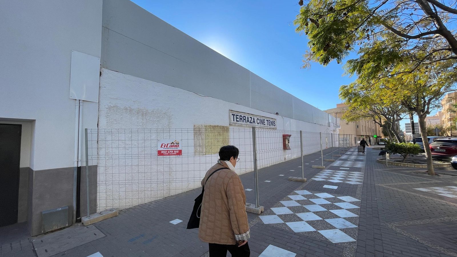 Una garruchera camina junto al cine, totalmente vallado.