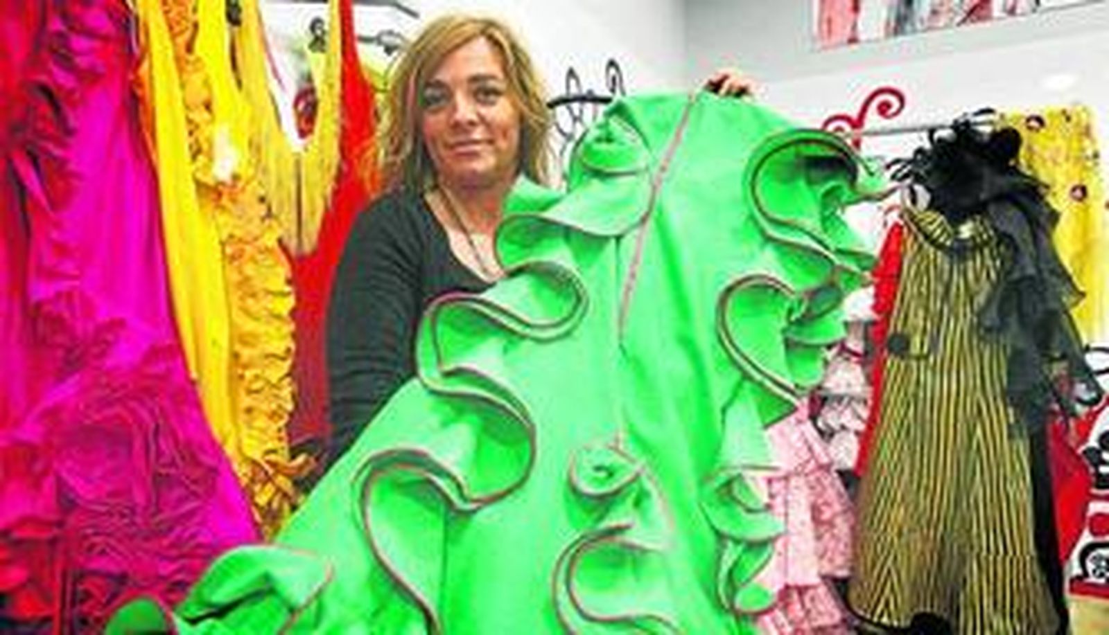 Eva Zamorano, en su taller de la calle Beato Diego con algunos de los vestidos que hoy desfilarán en los Museos de la Atalaya de Jerez.
