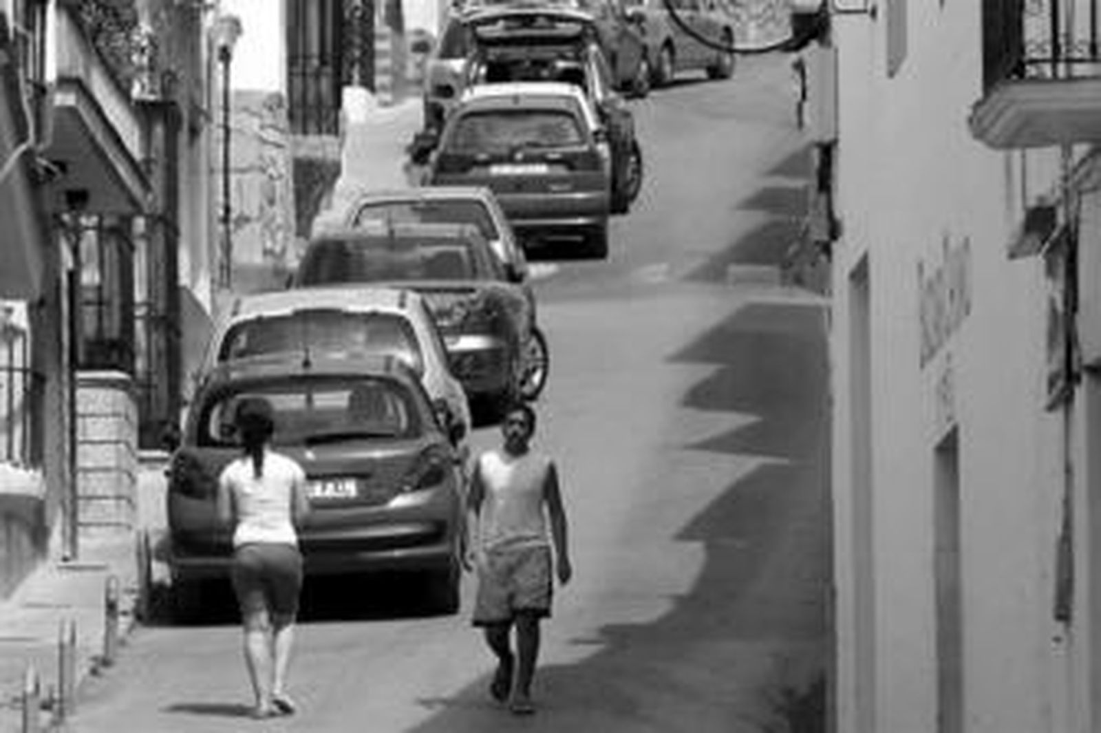 Vecinos pasean por la calle principal del pueblo, ayer.