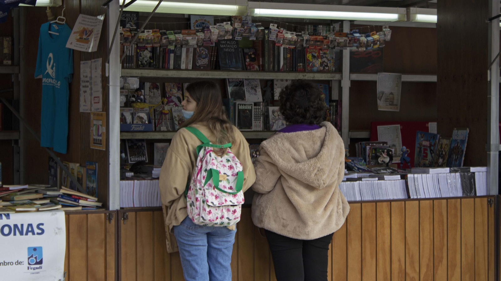 Dos personas observan un puesto de la Feria del Libro de Algeciras.
