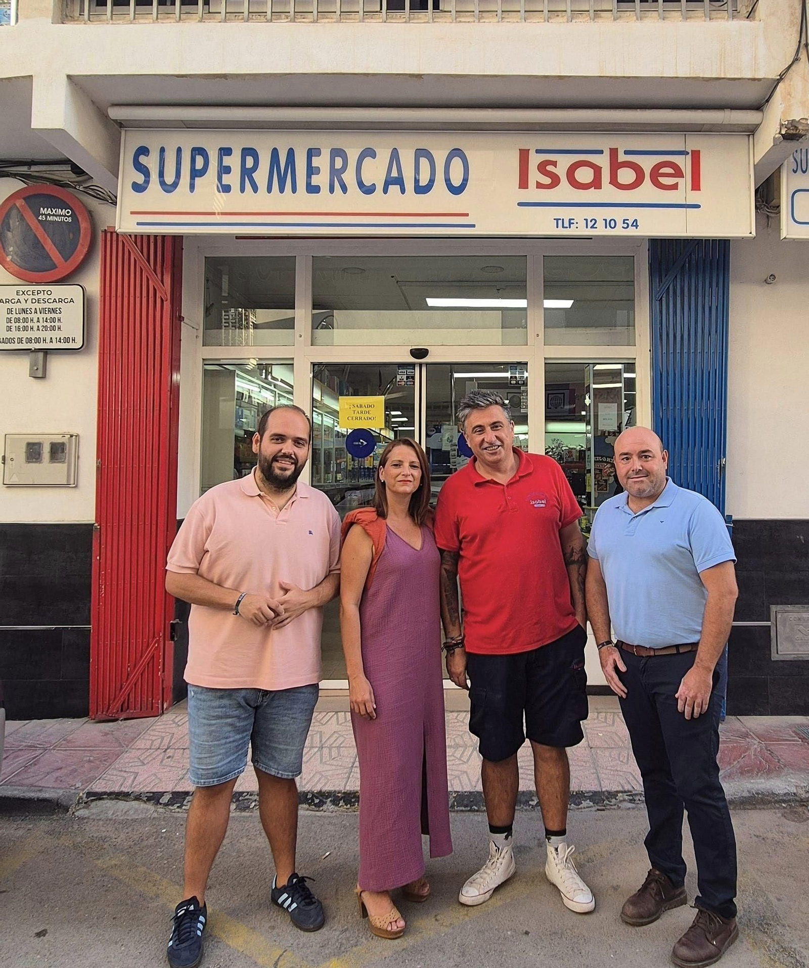 La alcaldesa, María del Mar Alfonso, posa junto al pregonero de las fiestas de San Francisco 2024 frente a su negocio