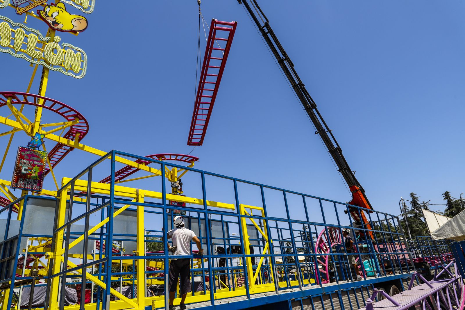 Operarios se afanan en el desmontaje de una atracción