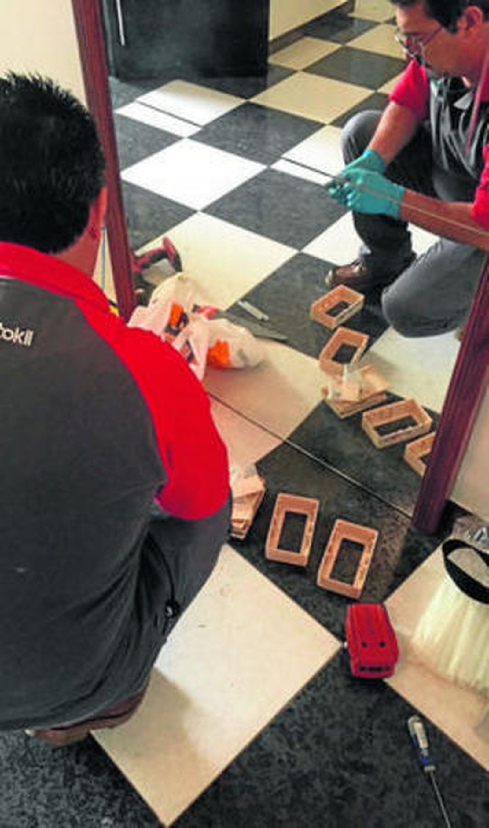 Dos técnicos durante la instalación de cebos en las viviendas afectadas.