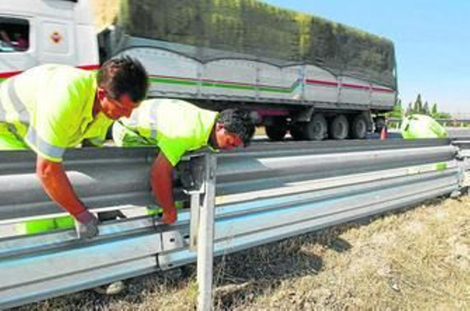Operarios de carreteras instalan en una de las vías de la provincia la doble bionda para los motoristas.