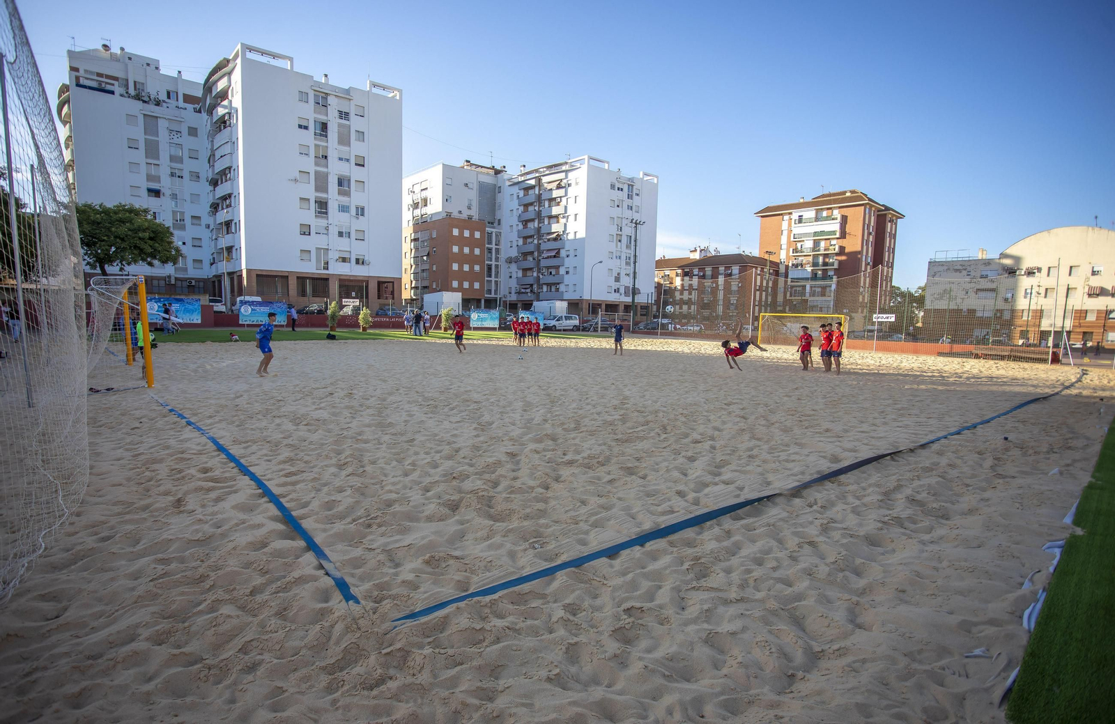 Varios niños jugando en el campo de fútbol playa.