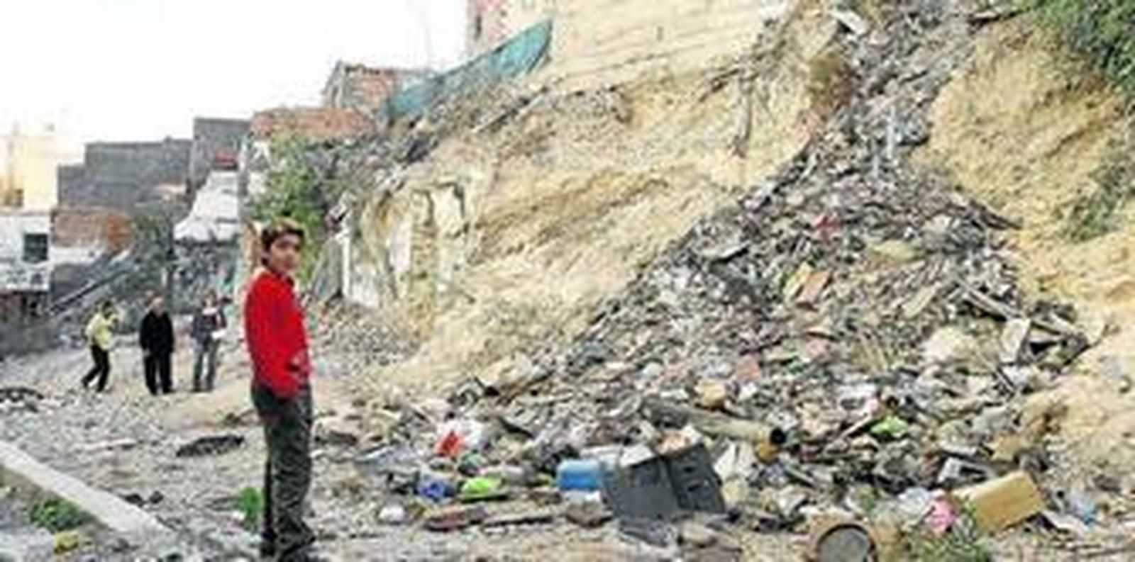 Un joven de La Chanca junto a un montón de escombros.